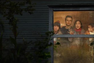 Key art officiel du film Netflix The Last House : une famille de quatre personnes enfermée derrière la fenêtre d'une maison plongée dans la nuit