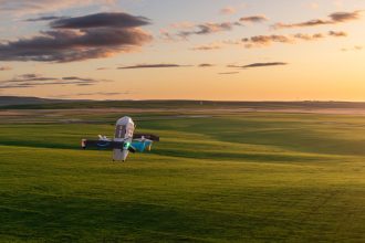 Drone Amazon Prime Air en vol au-dessus d'un champ, livraison par drone