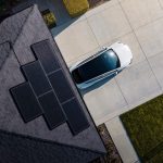 Tesla solar panels installes sur le toit d une maison, avec une Tesla garee dans l allee