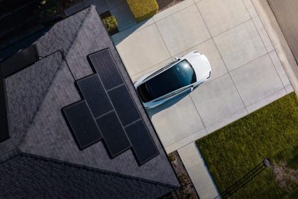 Tesla solar panels installes sur le toit d une maison, avec une Tesla garee dans l allee