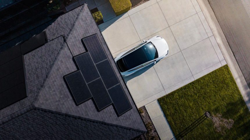 Tesla solar panels installes sur le toit d une maison, avec une Tesla garee dans l allee