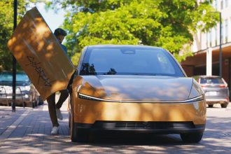 Tesla Cybercab doré en circulation à Austin, passager montant par la porte papillon, robotaxi sans volant pour le lancement public des courses RoboTaxi
